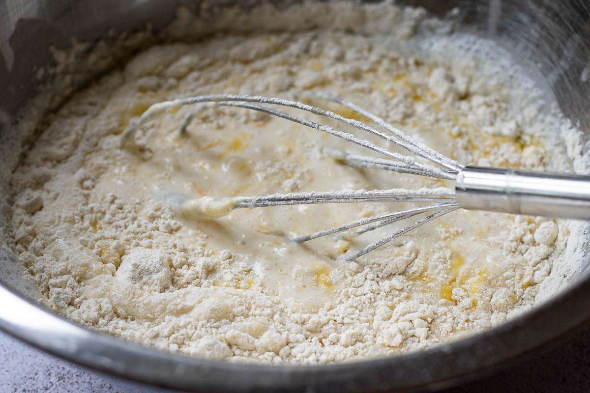 Mixing sourdough discard crepe batter with a balloon whisk.