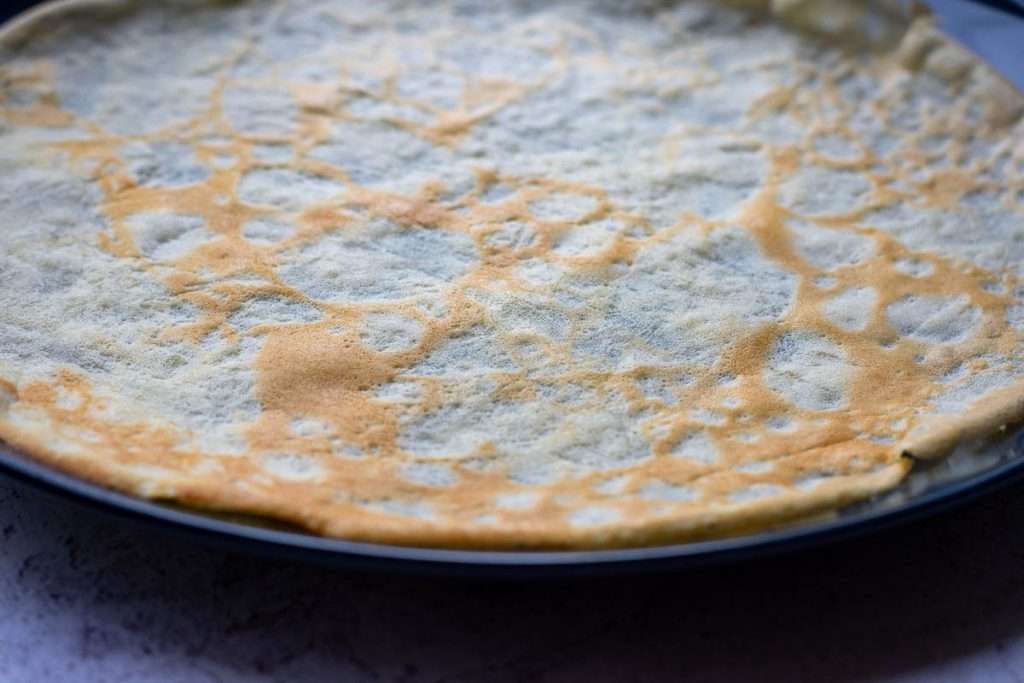 Sourdough crepe flipped to cook on the other side.
