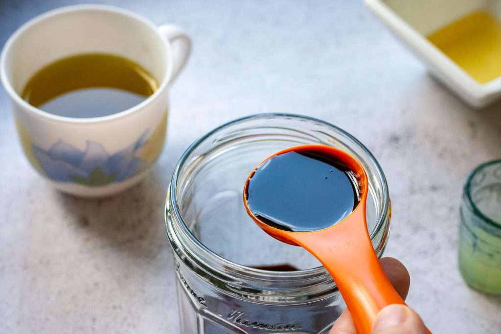 Measuring spoon with pomegranate molasses.