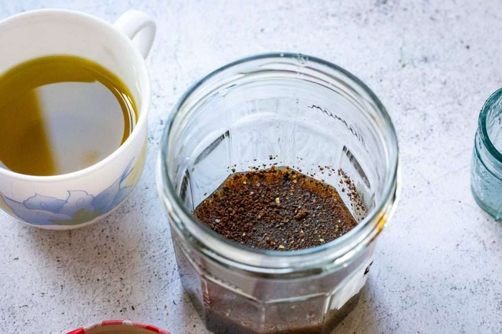 Pomegranate molasses and seasoning in a glass jar.