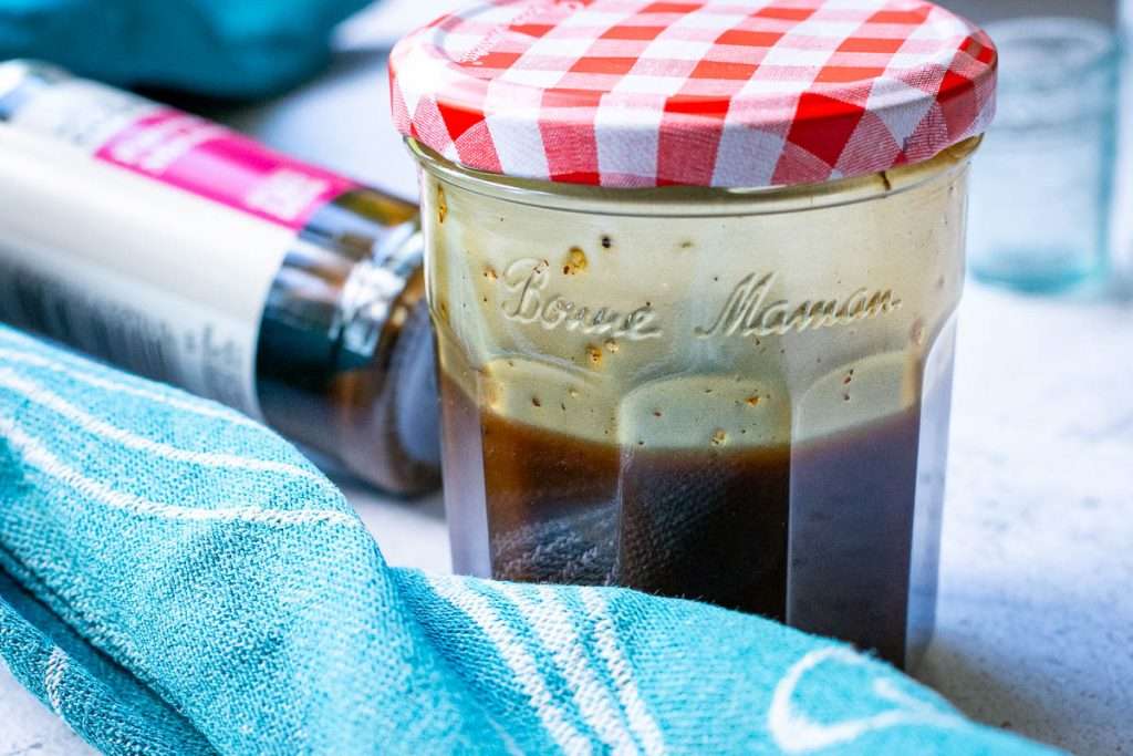 Emulsified pomegranate molasses salad dressing in a jar.