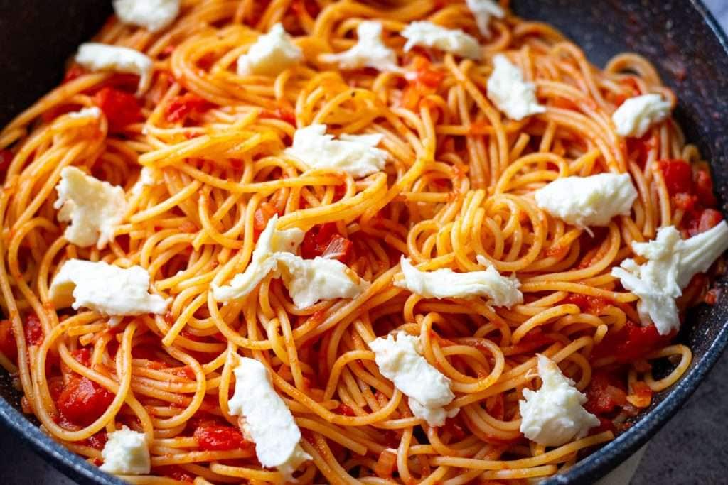 Mozzarella on top of tomato pasta.