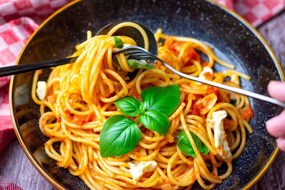 Tomato and mozzarella sapghetti wrapping around the fork.
