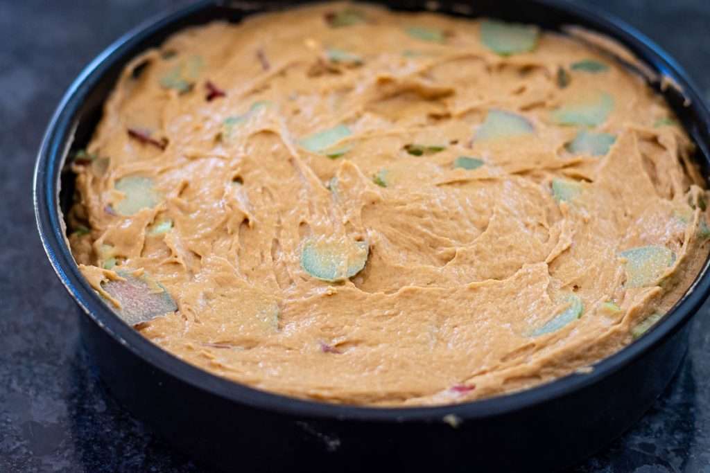 Rhubarb cake batter in a cake tin.