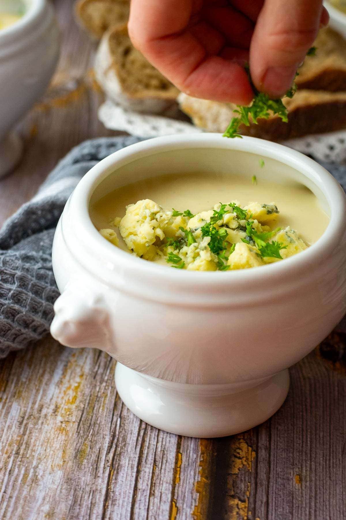 Scatterring parsley on top of cauliflower and stilton soup.