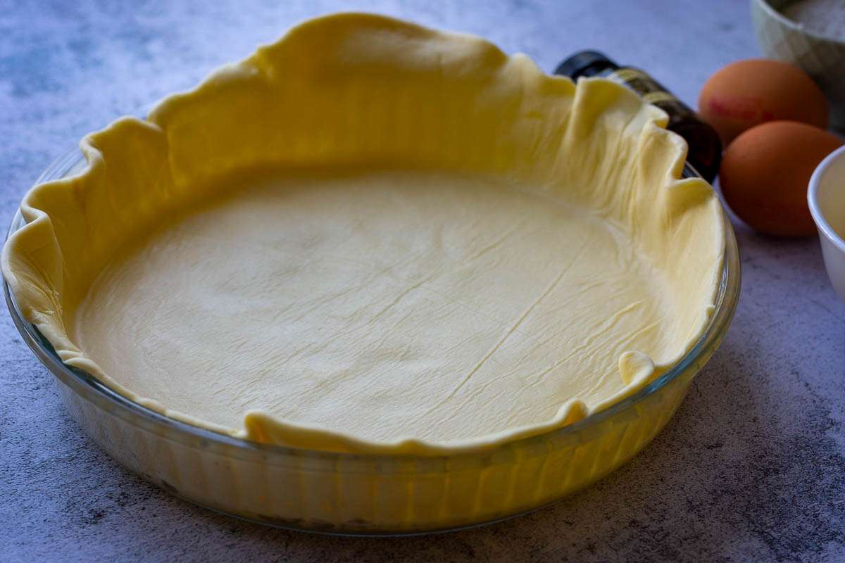 Lining glass tart pan with shortcrust pastry.