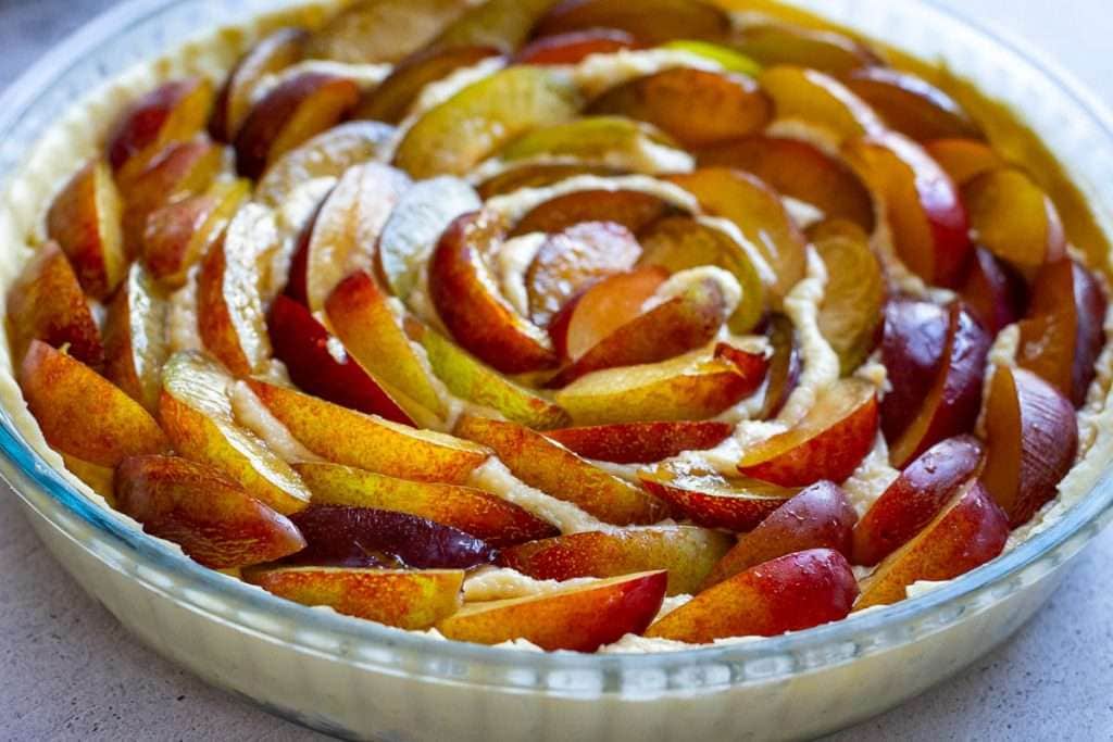 Plum slices arranged on top of frangipane.