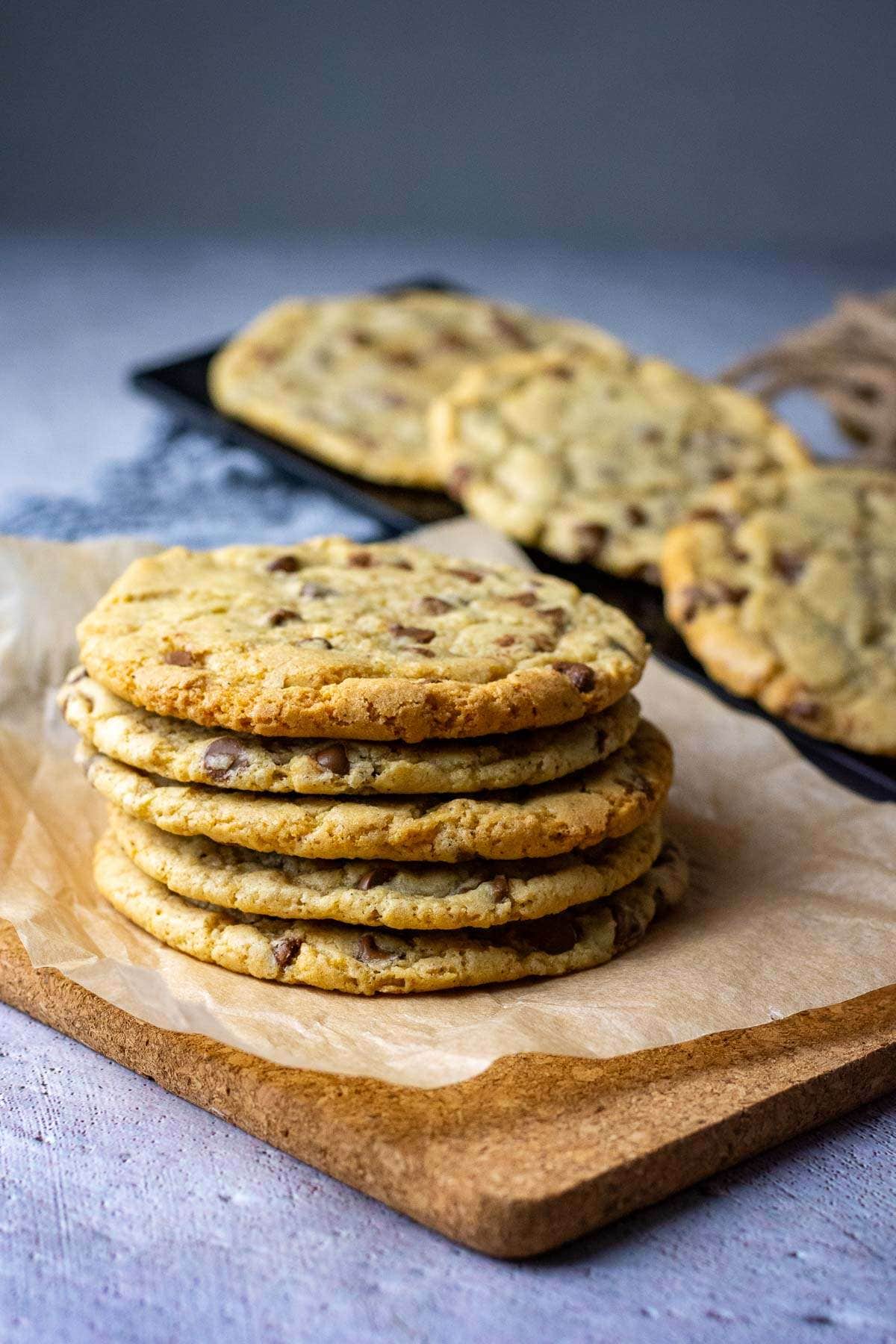 A stack of sourdough chocolate chip cookies on a piece of parchment paper.