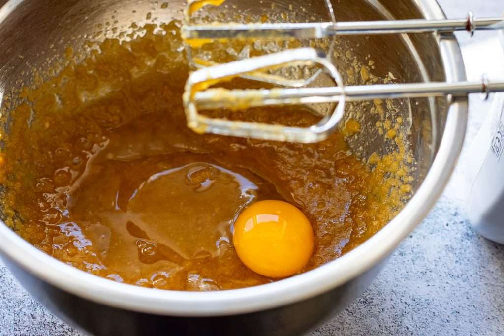 An egg added into the mixing bowl.