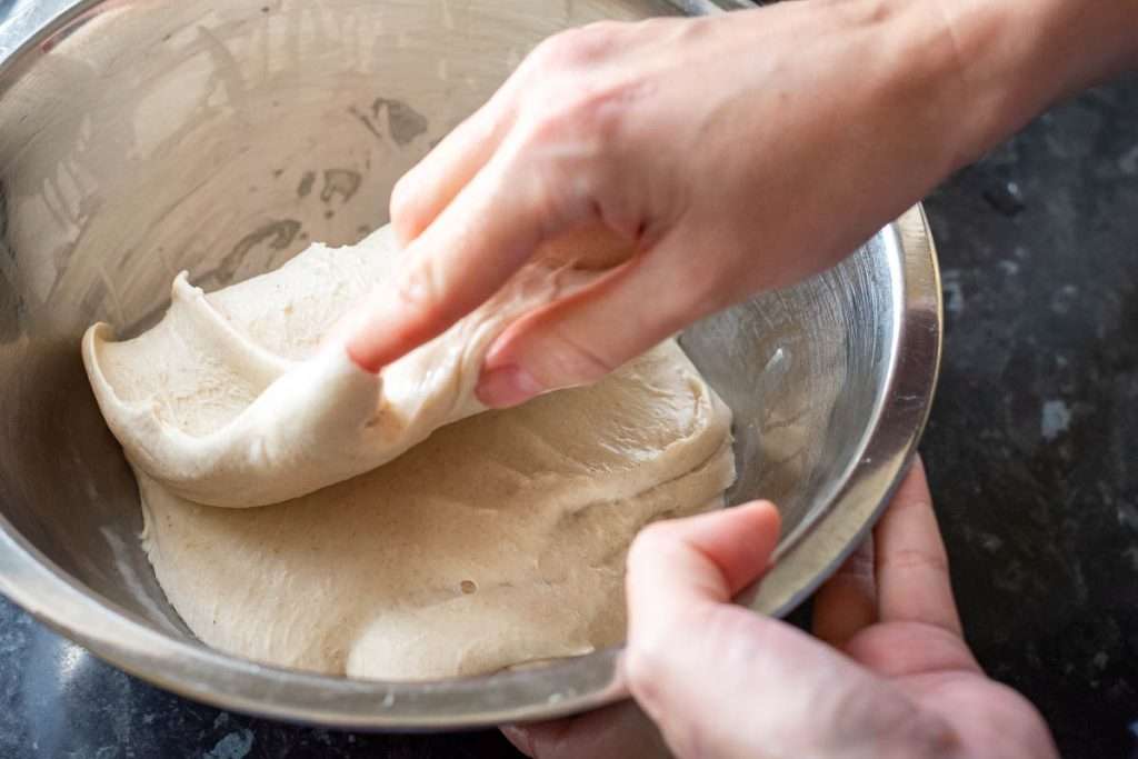 Folding the stretched out side of sourdough over the rest of the dough.