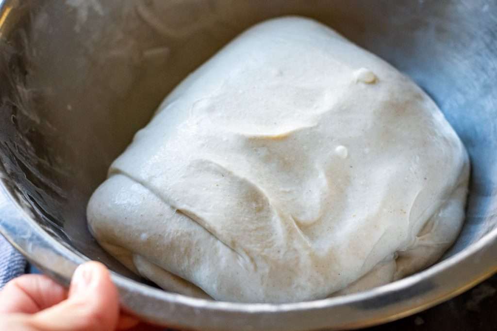 Sourdough stretched and folded left to rest in a metal bowl.