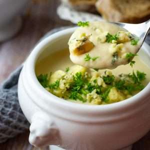 Cauliflower and blue cheese soup in a white soup bowl.