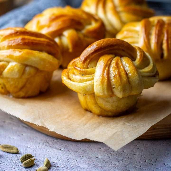 Swedish Sourdough Cardamom Buns on a piece of parchment paper.
