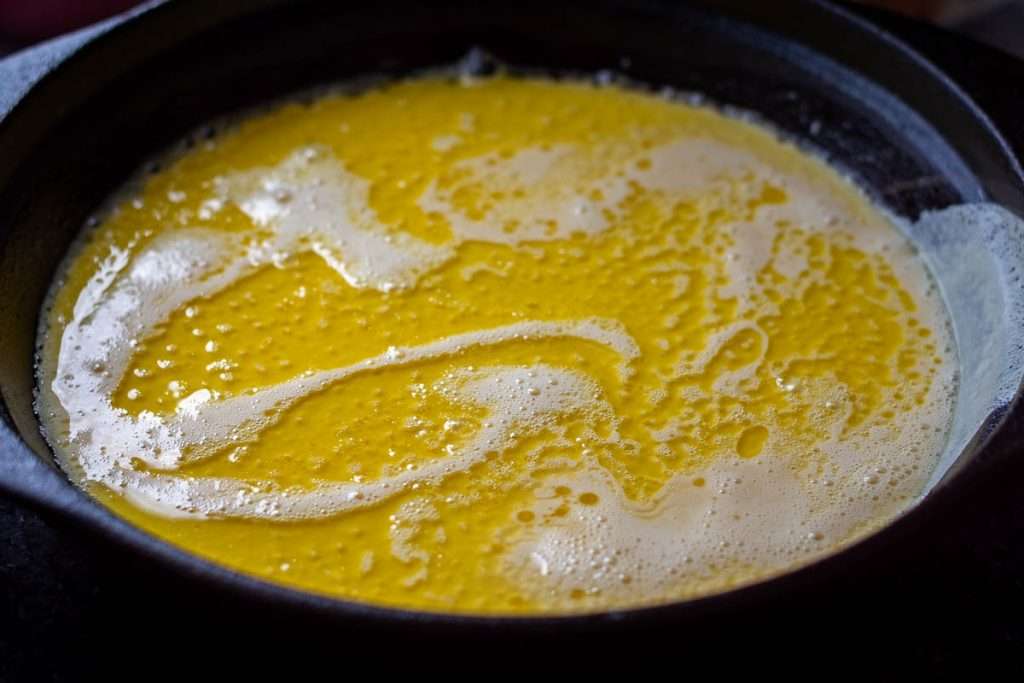 Pancake batter in a cast iron skillet.