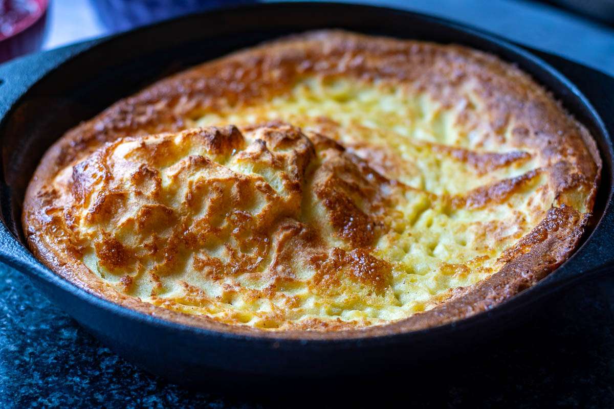 Sourdough Dutch Baby in a cast iron skillet fresh out the oven.
