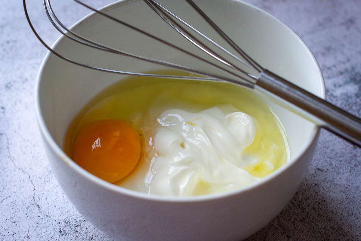Cheesy custard ingredients in a small white bowl.