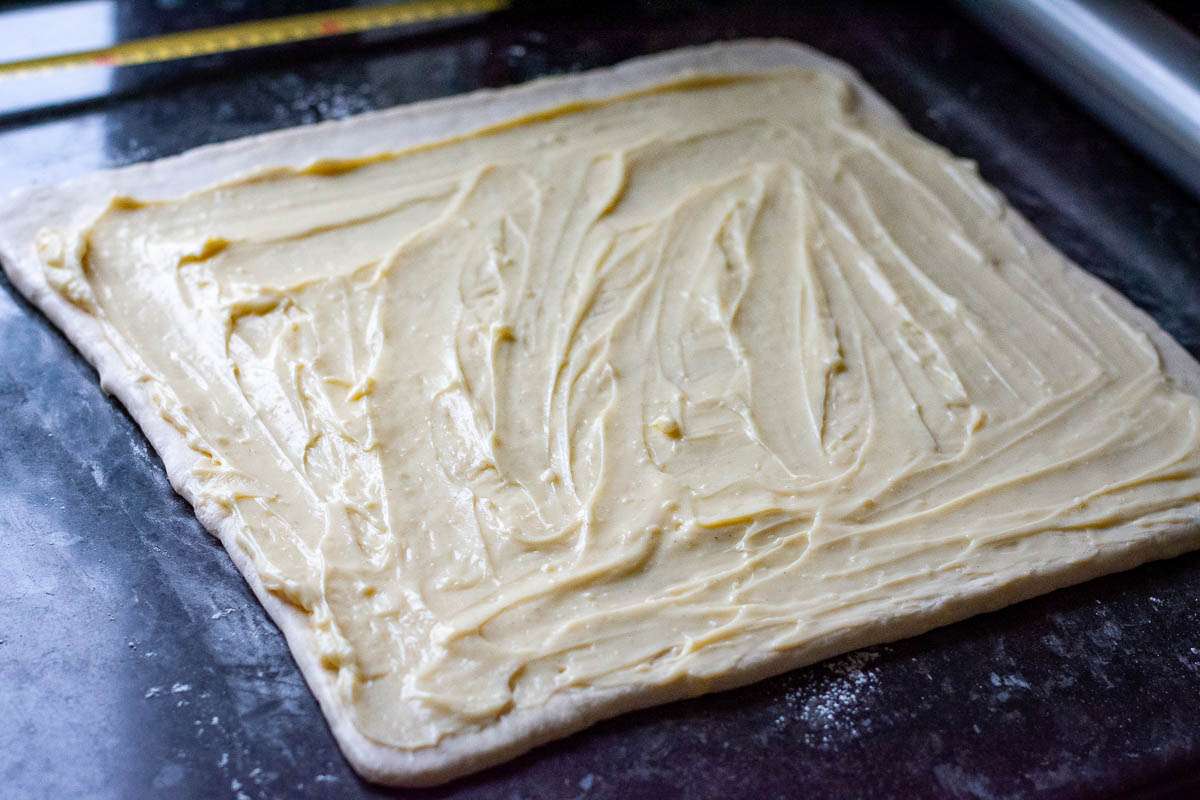 Creme pat spread across the surface of the laminated sourdough pastry.