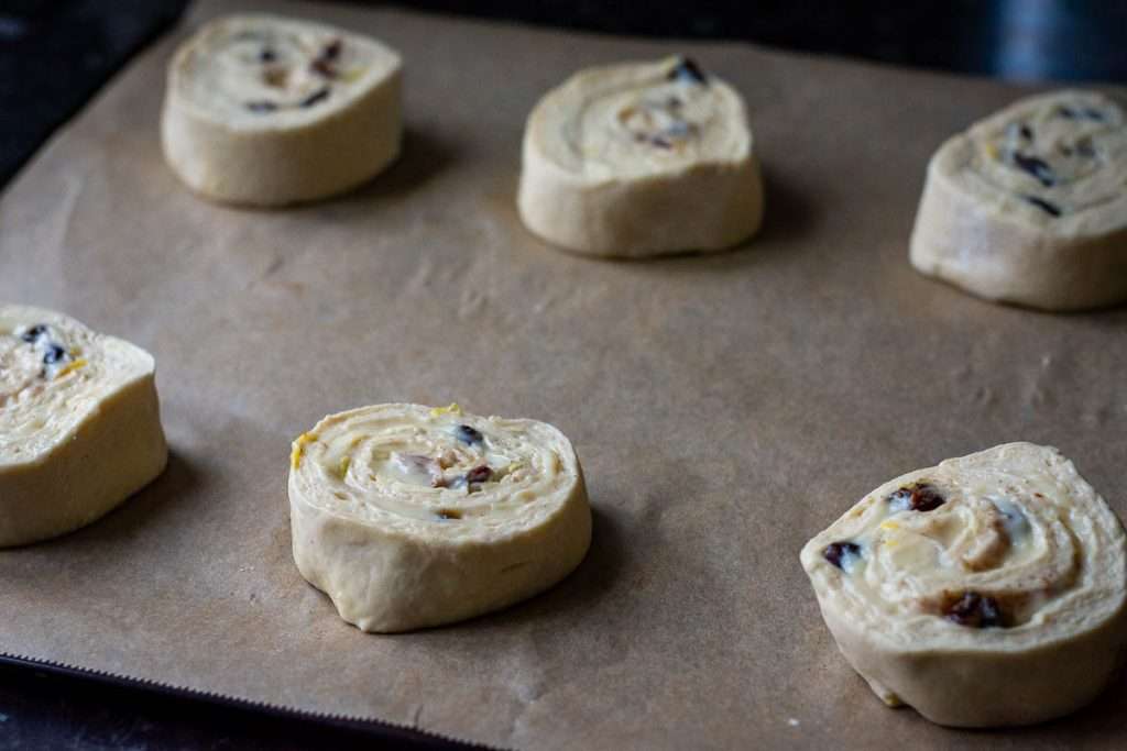 Pain aux raisins arranged on a baking sheet lined with parchment paper.