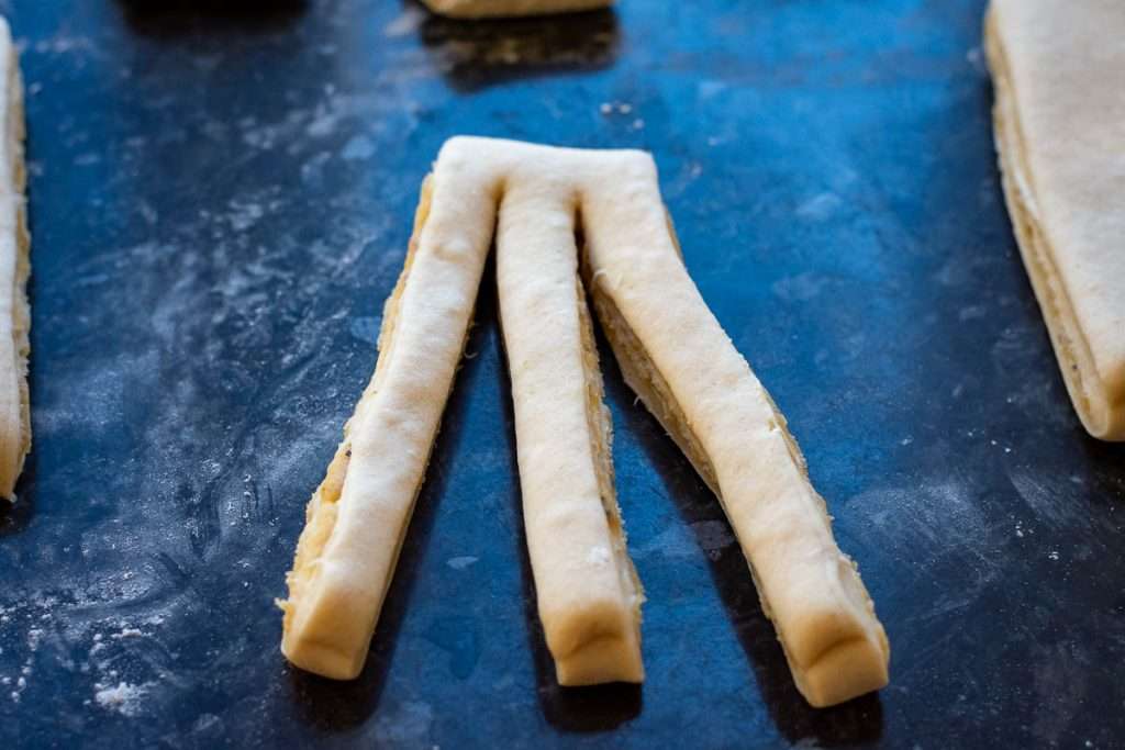 One piece of filled dough cut into three with one side intact.