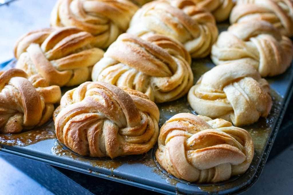 Baked sourdough swedish buns with cardamom still in the muffin tin.
