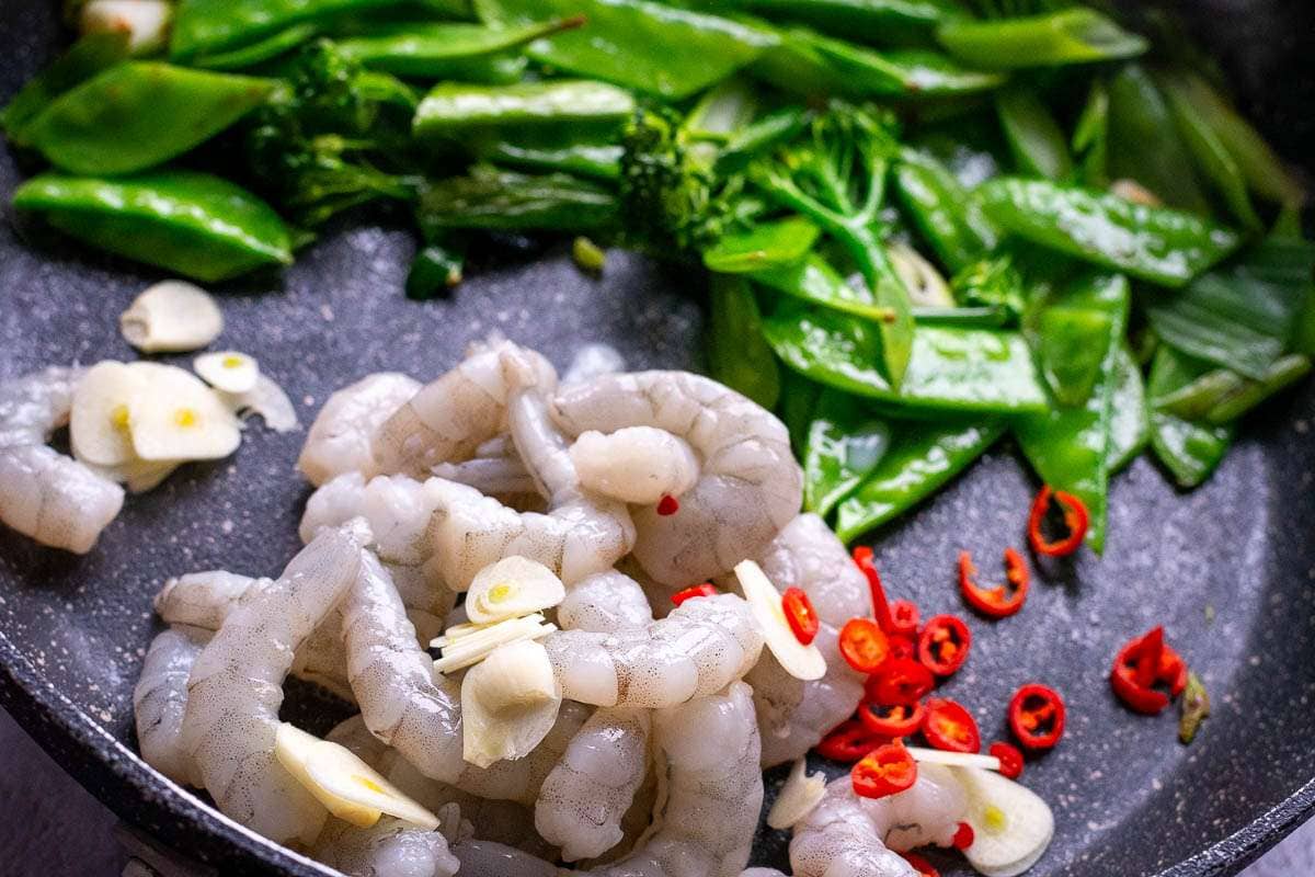 Prawns, garlic and chilli added to the vegetable pan.