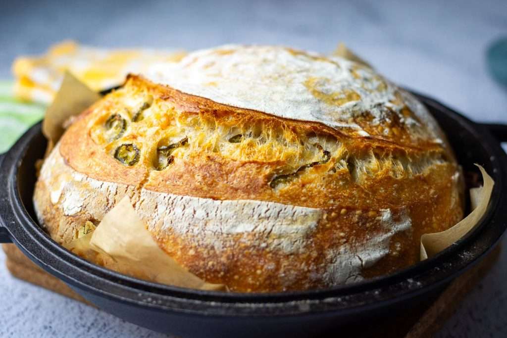 Jalapeno Cheddar Sourdough straight out of the oven on the lid of a Dutch oven.