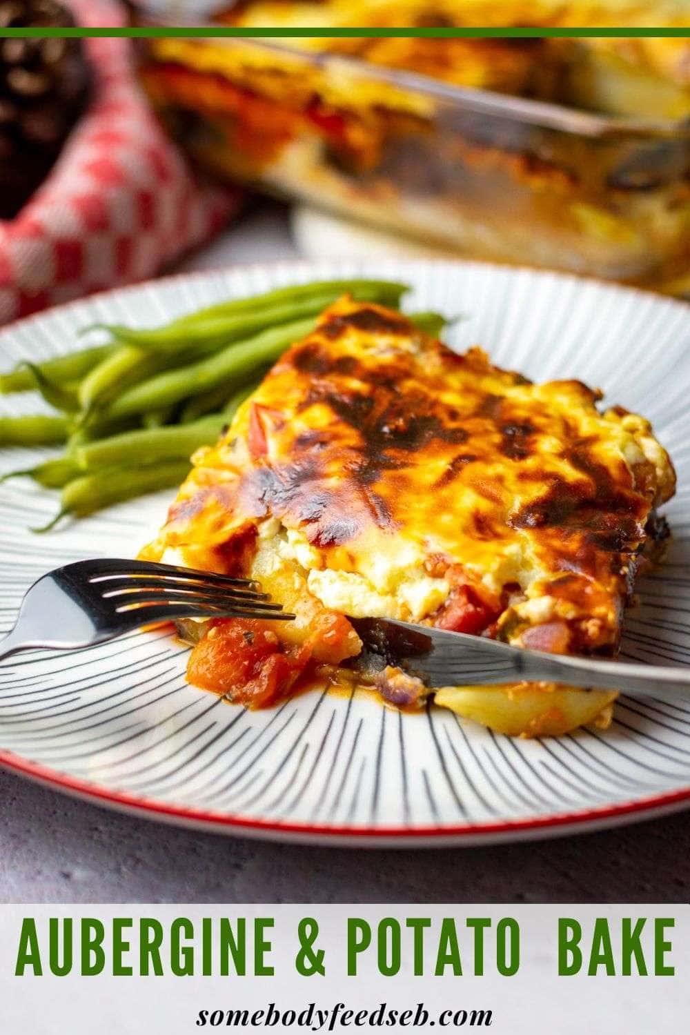 A slice of aubergine and tomato bake with potatoes on a large plate with cutlery approaching. Pin for Pinterest.