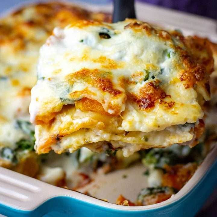 Butternut squash and spinach lasagan piece being served.
