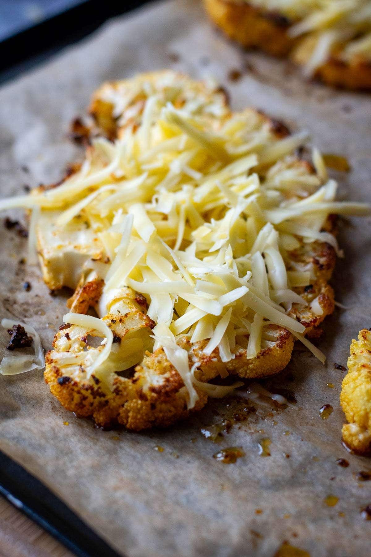 Grated cheese on top of the roasted cauliflower steak.