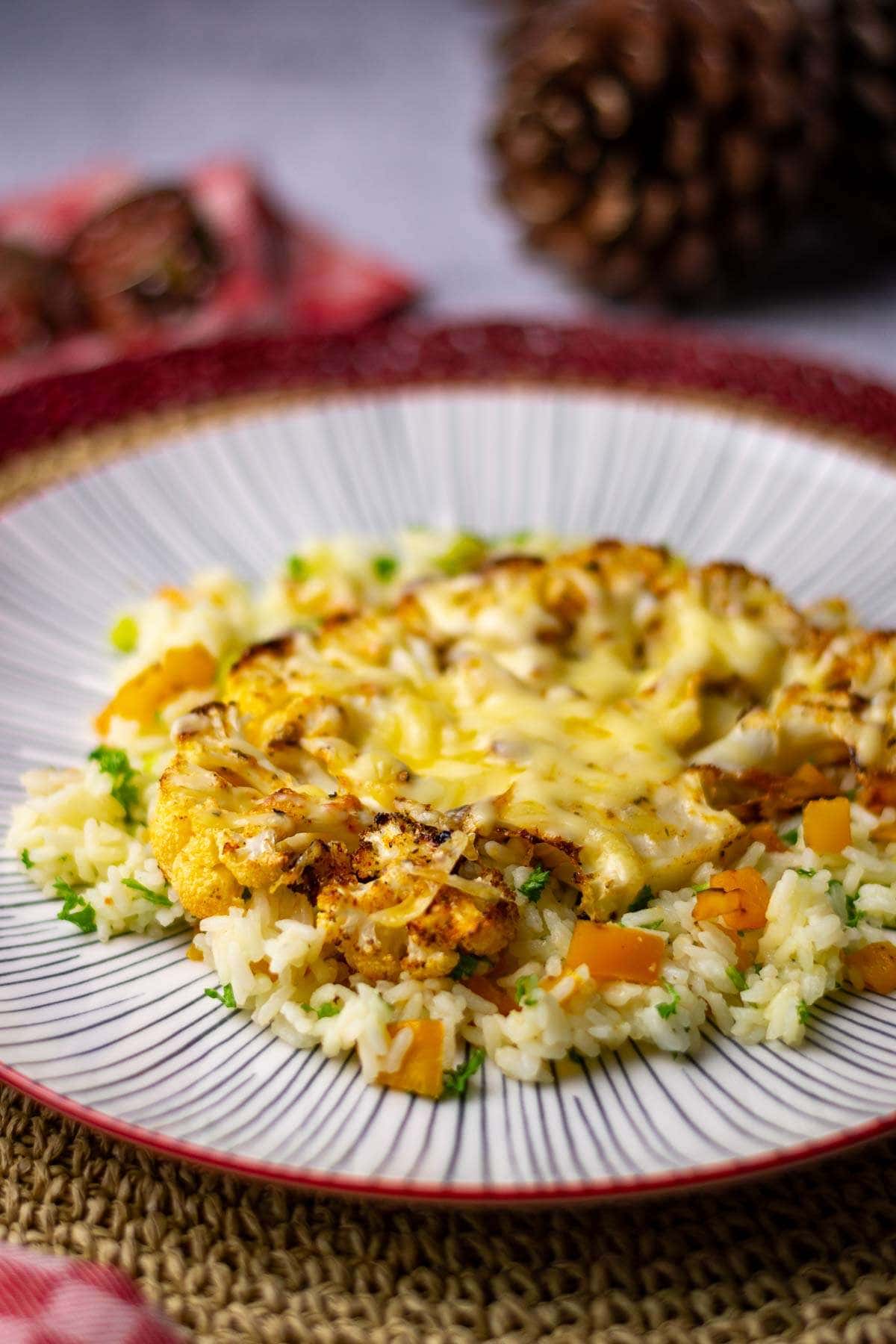 Roasted Cauliflower Steak on a bed of rice with cheese melted on top.