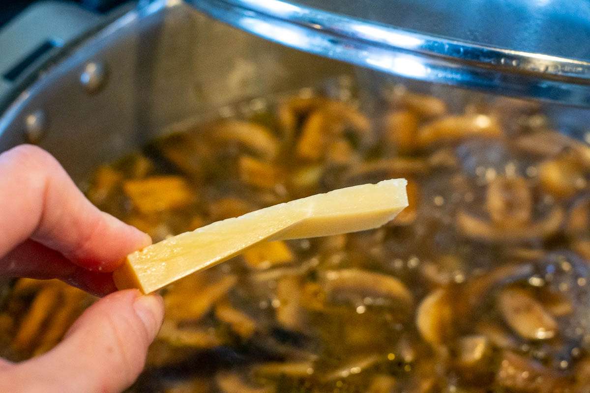 Parmesan rind being added to the soup.