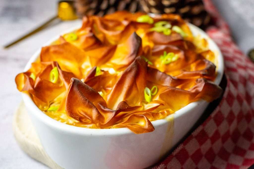 Baked pie garnished with spring onion slices.