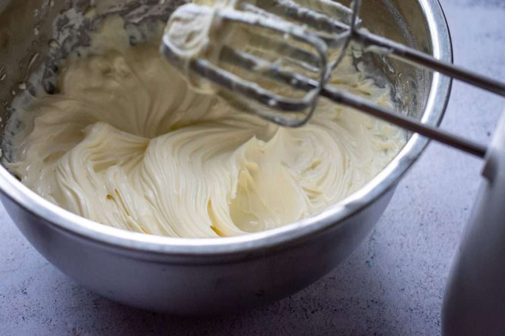Smooth cream cheese and icing sugar mixture in a bowl after mixing.