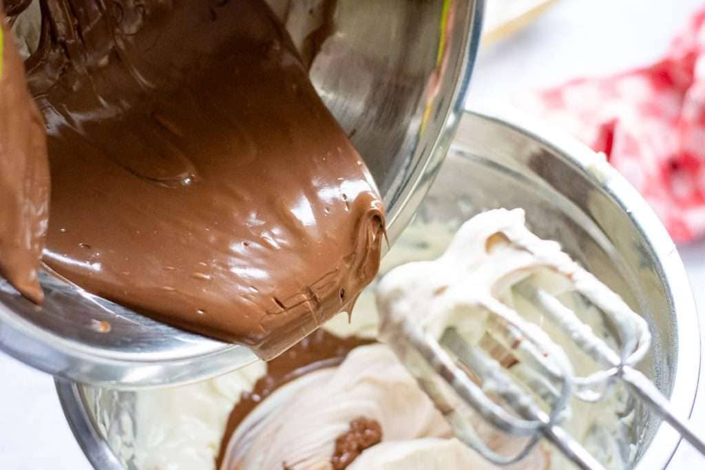 Adding melted chocolate to cream cheese mixture.