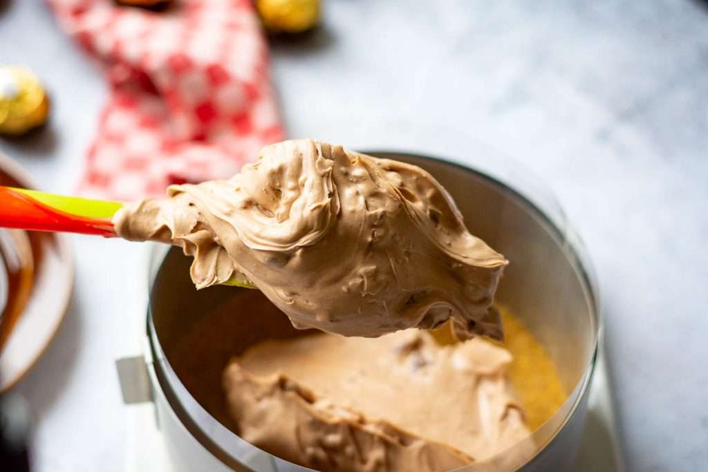 Spooning the cheesecake filling on top of the biscuit base.