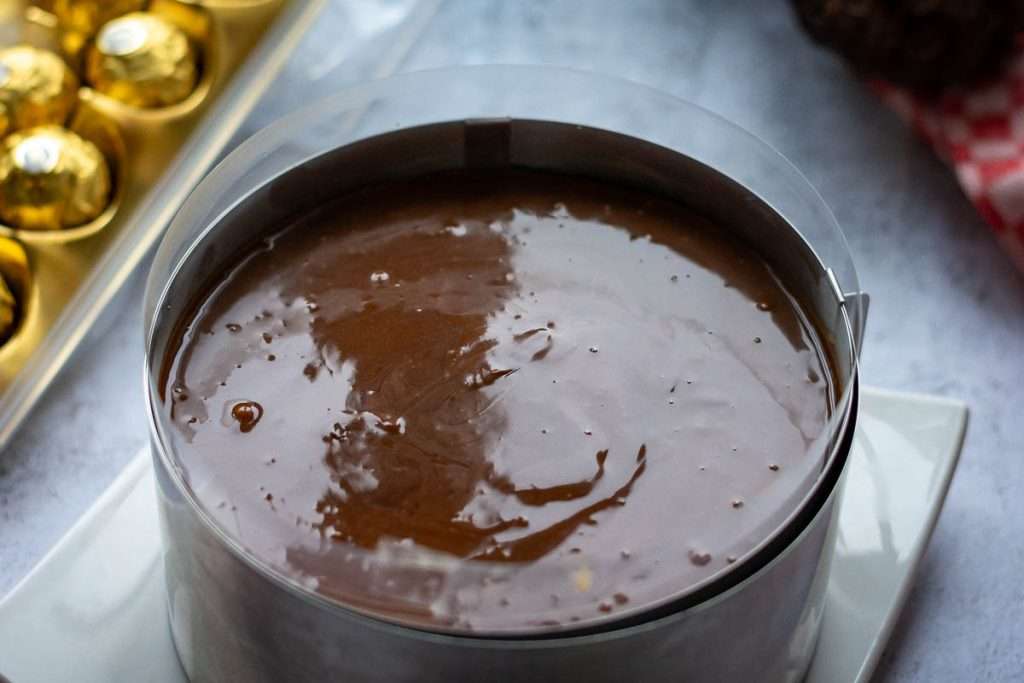 Chocolate ganache topping on top of the set cheesecake.