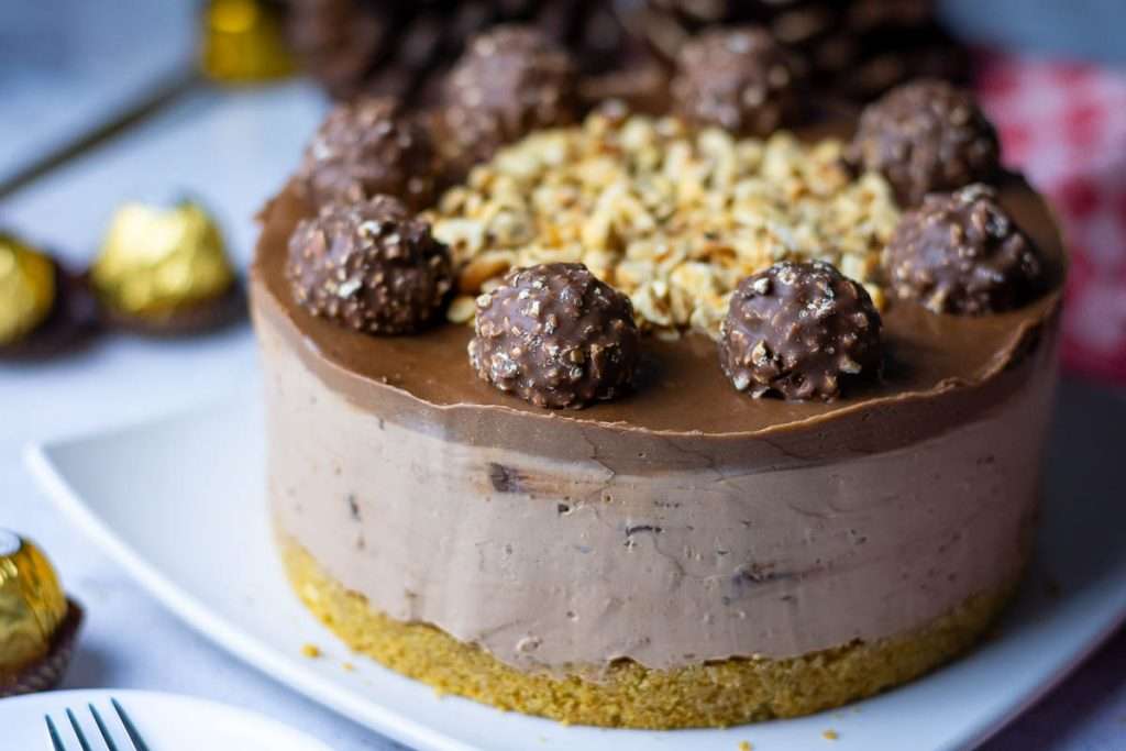 Ferrero Rocher cheesecake taken out of the tin and acetate tape and ready to be sliced.