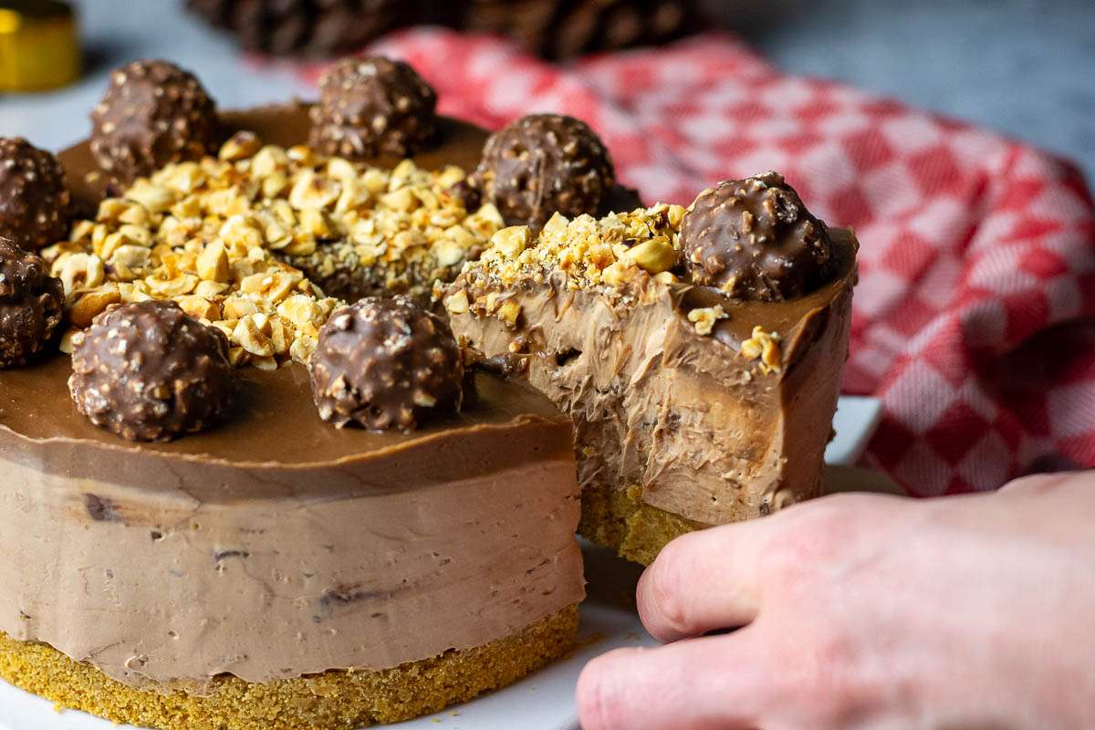 A slice of ferrero rocher cheesecake being cut.