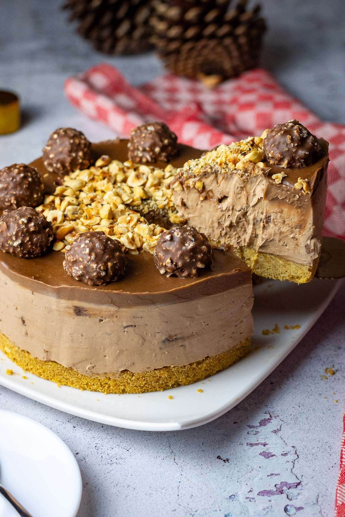 A slice of no-bake ferrero rocher cheesecake being cut.