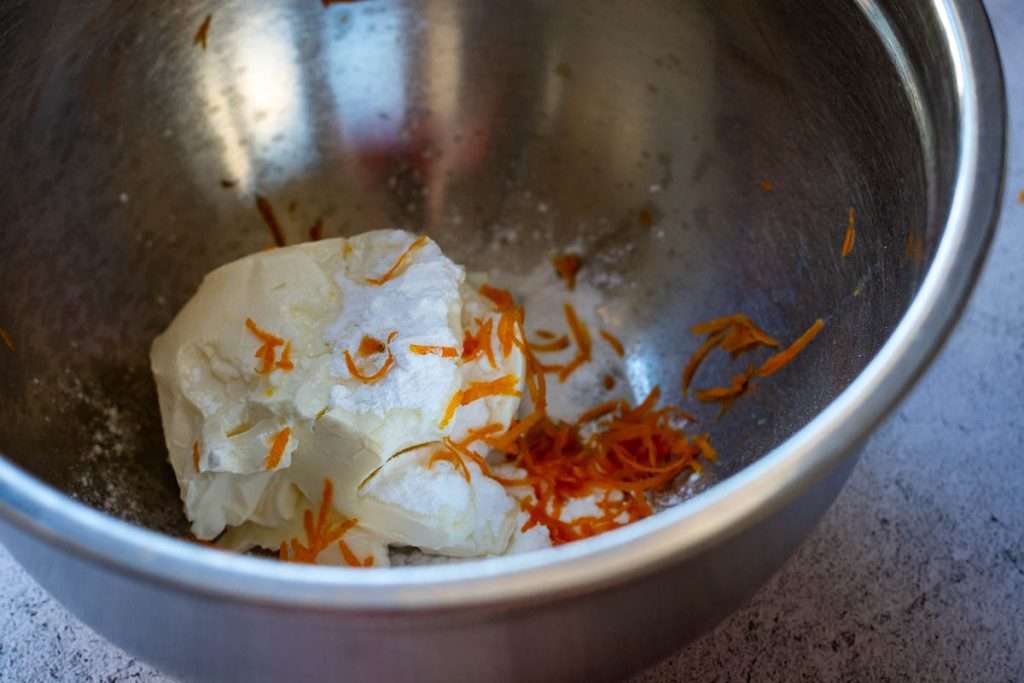 Cream cheese, icing sugar and orange zest in a mixing bowl.