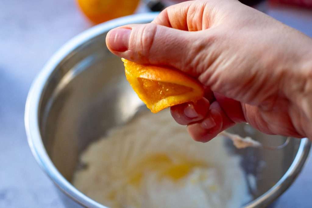 Squeezing orange juice into the cream filling for crepes.