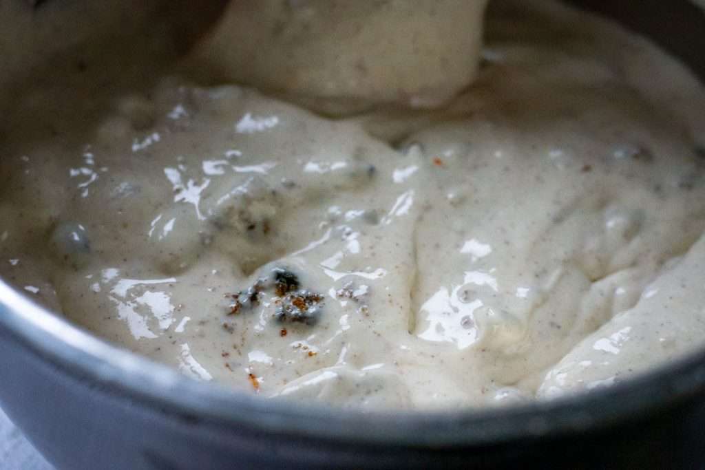 Christmas cake cheesecake filling mixture in a large mixing bowl.