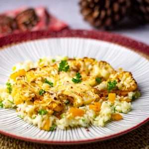Roasted Cauliflower Steak on a bed of rice with cheese melted on top.