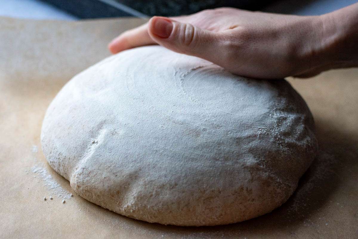 Inverted sourdough on a piece of parchment paper.