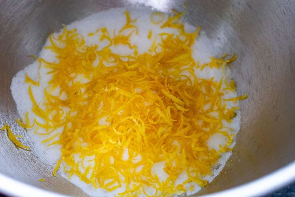 Lemon zest over the caster sugar in a large mixing bowl.
