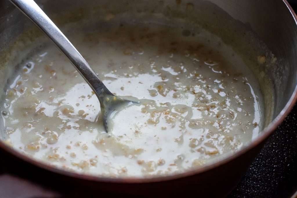 Cooked creamy oats in a saucepan.