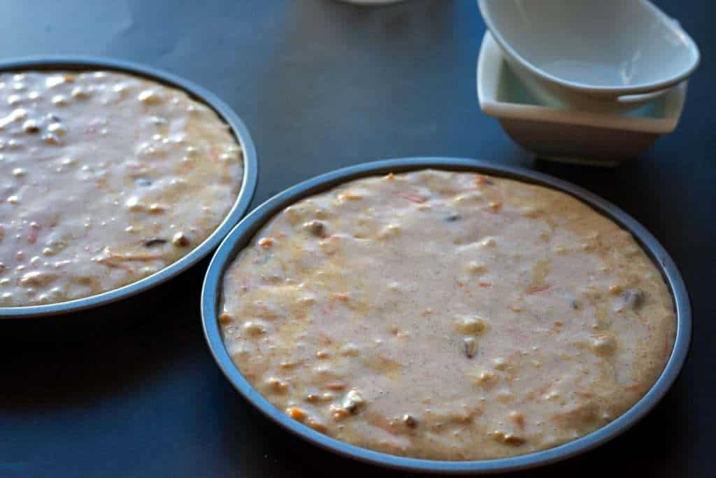Sourdough discard carrot cake batter divided between two cake tins.