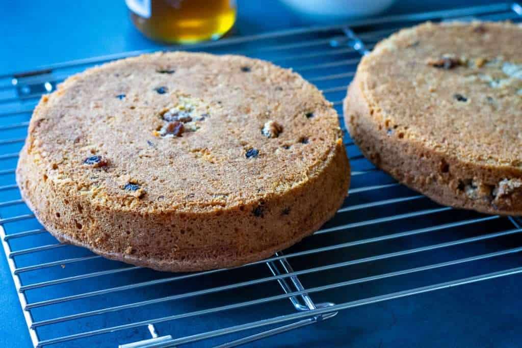 Two carrot cakes cooling on a wire rack.