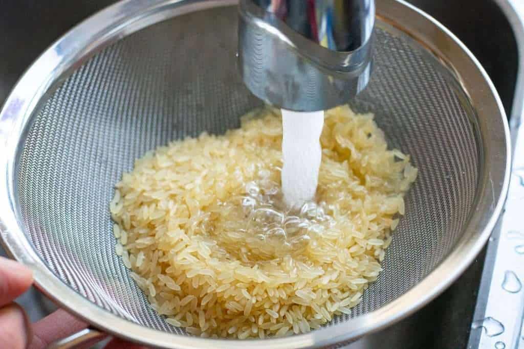 Rinsing rice under cold running water.
