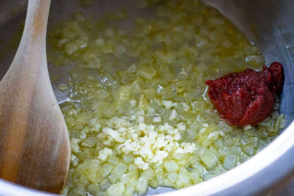 Onions, garlic and tomato puree in a pan.
